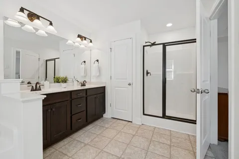 a spacious bathroom with a double vanity sink mirror and shower