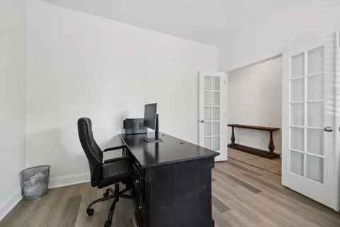a view of a workspace with furniture and wooden floor