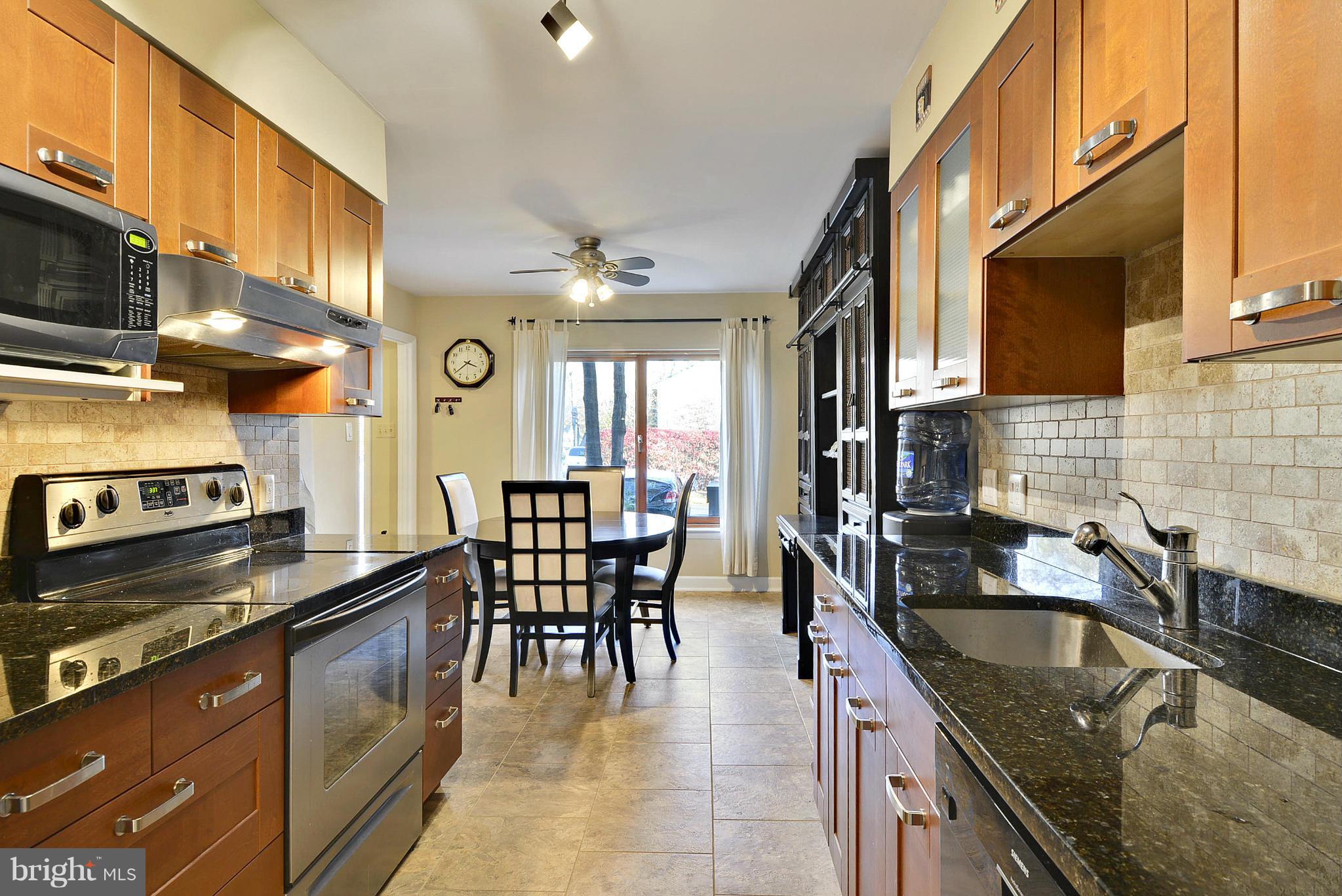 2024 Golf Course Drive Reston, VA 20191 - Photo 15 of 30 a kitchen with stainless steel appliances granite countertop a sink a stove counter space and cabinets