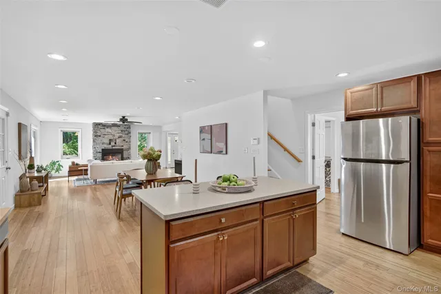 a kitchen with stainless steel appliances granite countertop a refrigerator a sink dishwasher a stove and a refrigerator with wooden floor