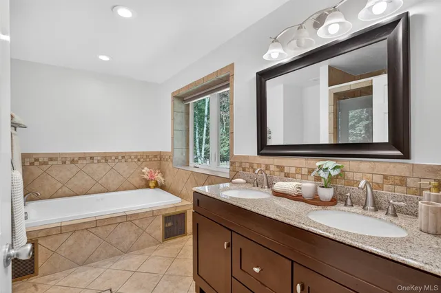 a bathroom with a granite countertop sink and a mirror