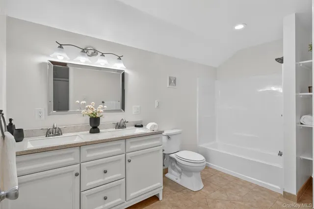 a bathroom with a double vanity sink toilet mirror and shower