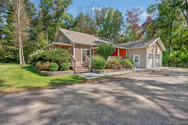 a front view of a house with a yard and potted plants