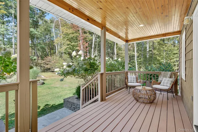 a view of a balcony with chairs and wooden floor