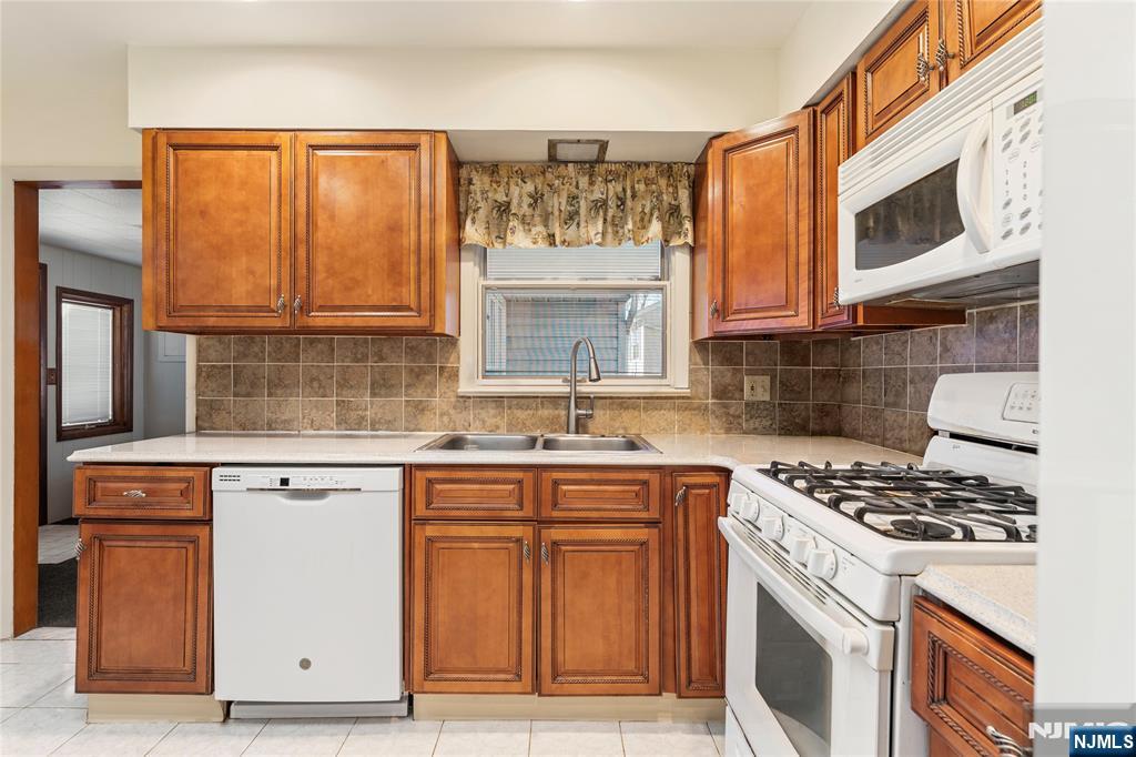 60 White Oak Road Parsippany, NJ 07054 - Photo 4 of 24 a kitchen with stainless steel appliances granite countertop a stove a sink and a microwave