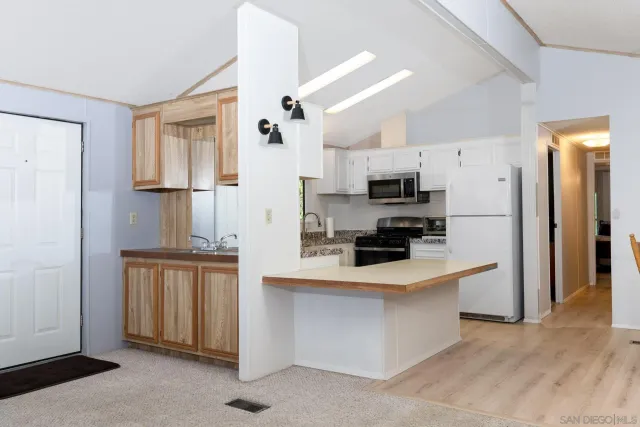 a kitchen with a white cabinets sink and stove