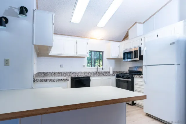 a kitchen with stainless steel appliances granite countertop a stove a refrigerator and a sink