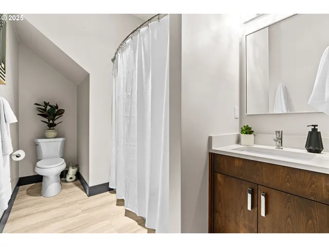 a kitchen with stainless steel appliances granite countertop a refrigerator a stove a sink dishwasher and a dining table with wooden floor