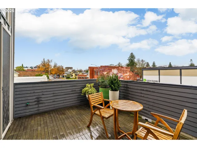 a living room with furniture a kitchen view and a wooden floor