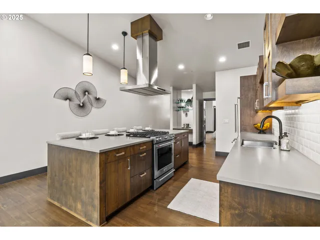 a kitchen with stainless steel appliances granite countertop a stove a sink and a refrigerator
