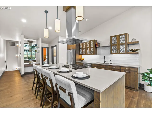 a living room with kitchen island furniture a refrigerator and a sink