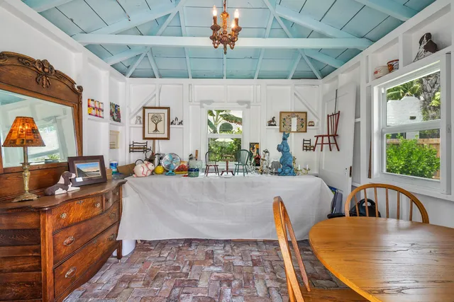 a view of a dining room with furniture one side kitchen view and wooden floor