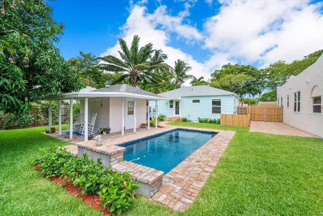a view of a house with swimming pool and a yard