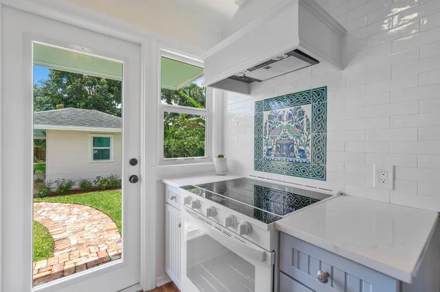 a view of a kitchen that shows a sink kitchen stove and a window