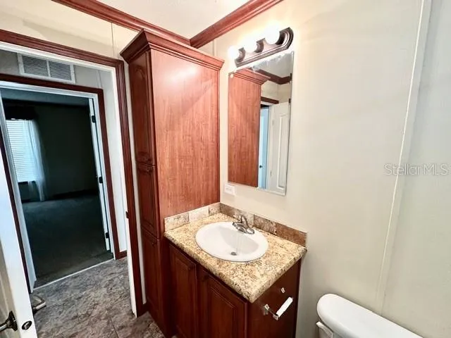 a bathroom with a granite countertop sink and a mirror
