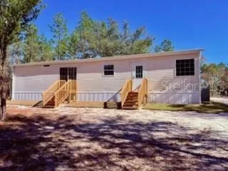 a view of a house with backyard and trees