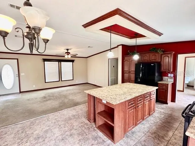 a room with a bed a chandelier and dresser