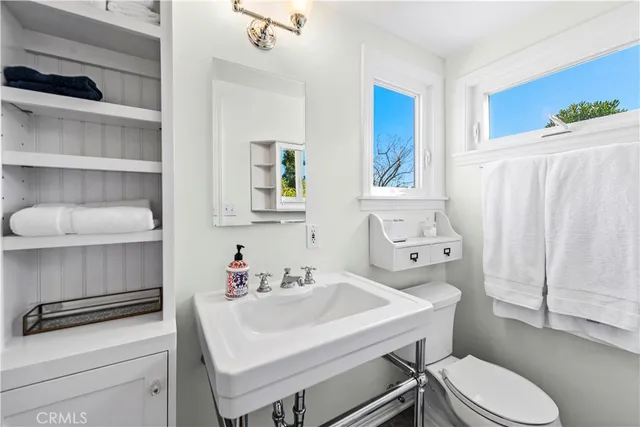 a bathroom with a sink toilet and a mirror