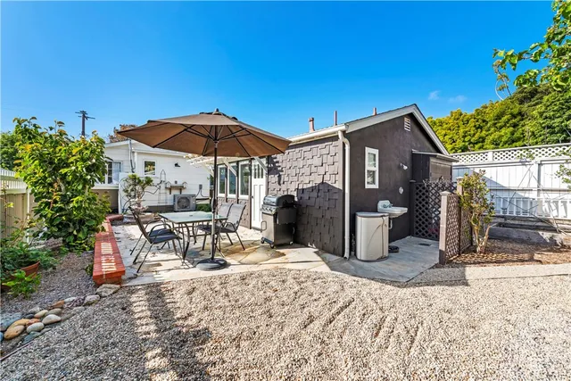 a view of a chairs and table under an umbrella in backyard
