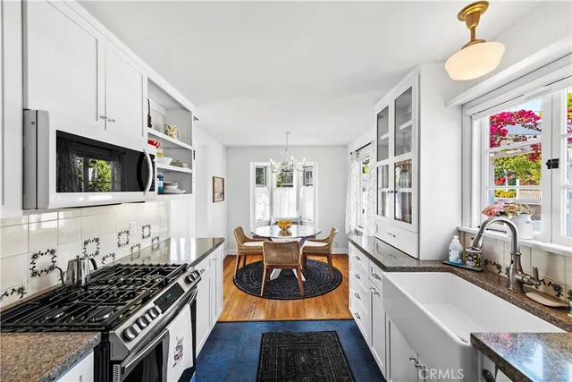 a kitchen with stainless steel appliances a stove a sink and a microwave