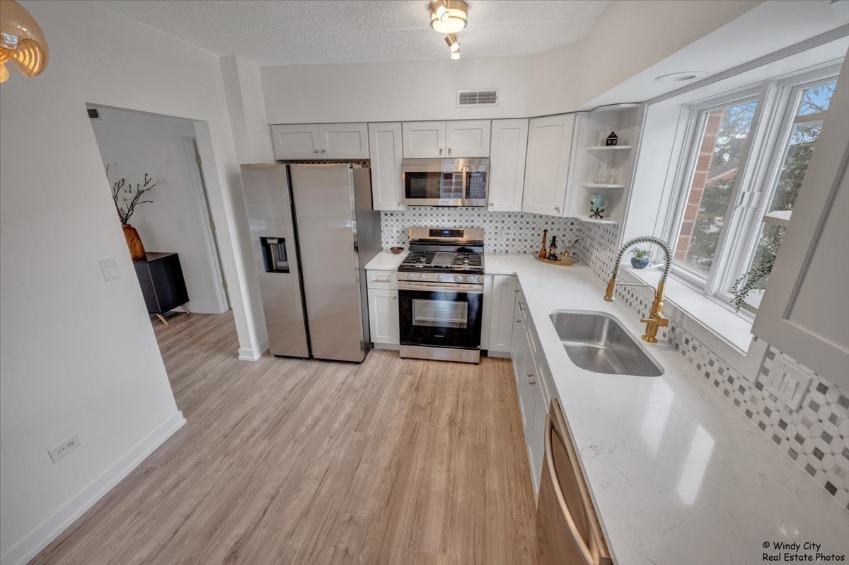455 West Front Street, Unit 2208 Wheaton, IL 60187 - Photo 11 of 20 a kitchen with stainless steel appliances a refrigerator a sink a stove top oven a refrigerator and dishwasher