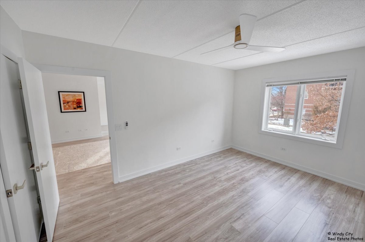 455 West Front Street, Unit 2208 Wheaton, IL 60187 - Photo 16 of 20 a view of an empty room with wooden floor and a window