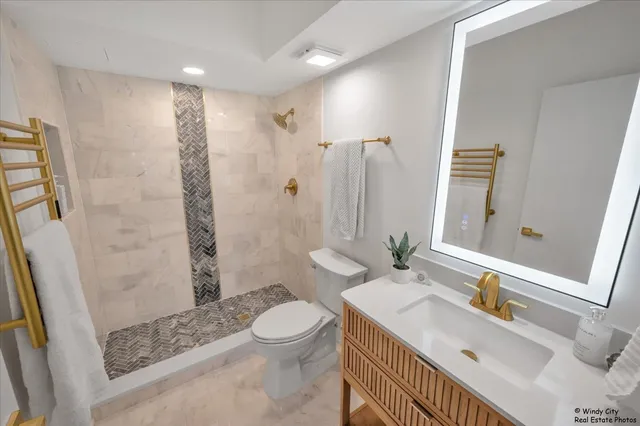 a view of a hallway with wooden floor and a bathroom