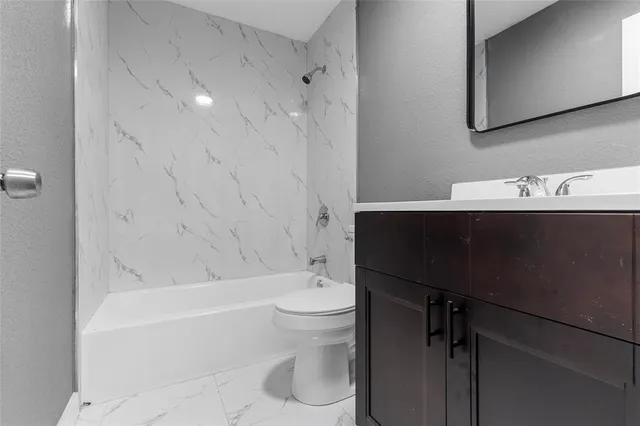 a bathroom with a sink mirror toilet and bathtub