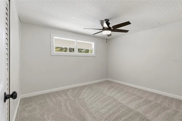 an empty room with a window and a fan
