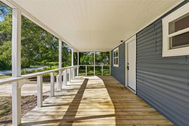 a view of balcony with wooden floor and fence