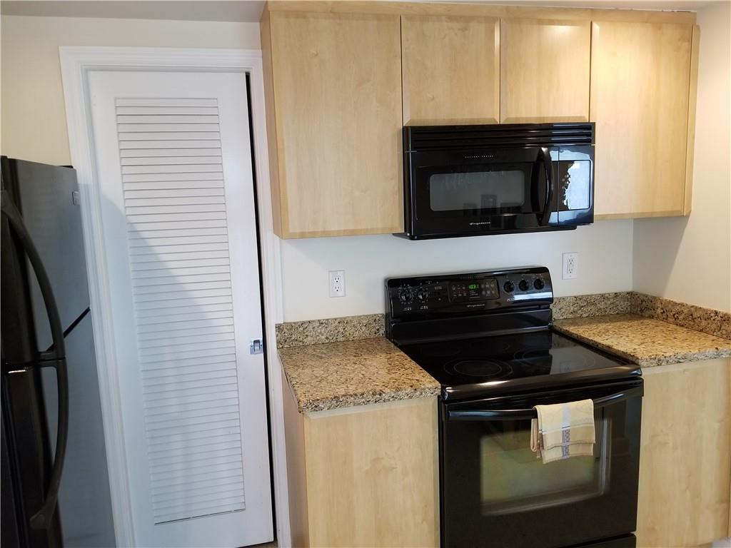 3208 Colony Club Road, Unit 6 Pompano Beach, FL 33062 - Photo 5 of 21 a kitchen with a stove and a microwave