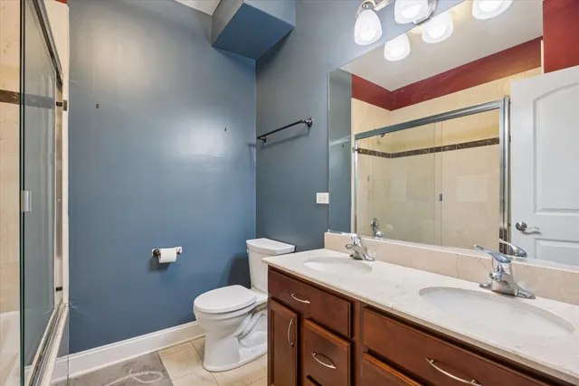 a bathroom with a granite countertop sink toilet a large mirror and shower