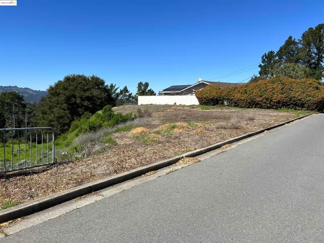 a view of a yard with wooden fence