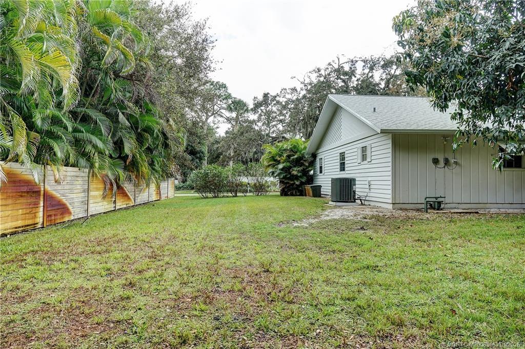 4 Miramar Road Sewall's Point, FL 34996 - Photo 23 of 31 a backyard of a house with plants and large tree