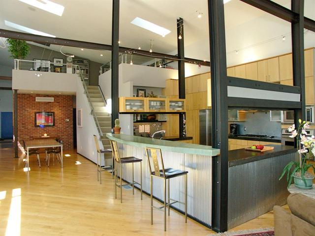 a kitchen with stainless steel appliances granite countertop a table and chairs