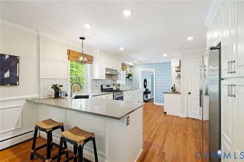 a kitchen with stainless steel appliances a counter space a sink a window and cabinets