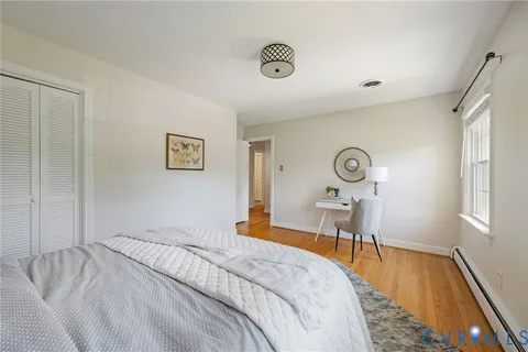 a bedroom with a bed and wooden floor