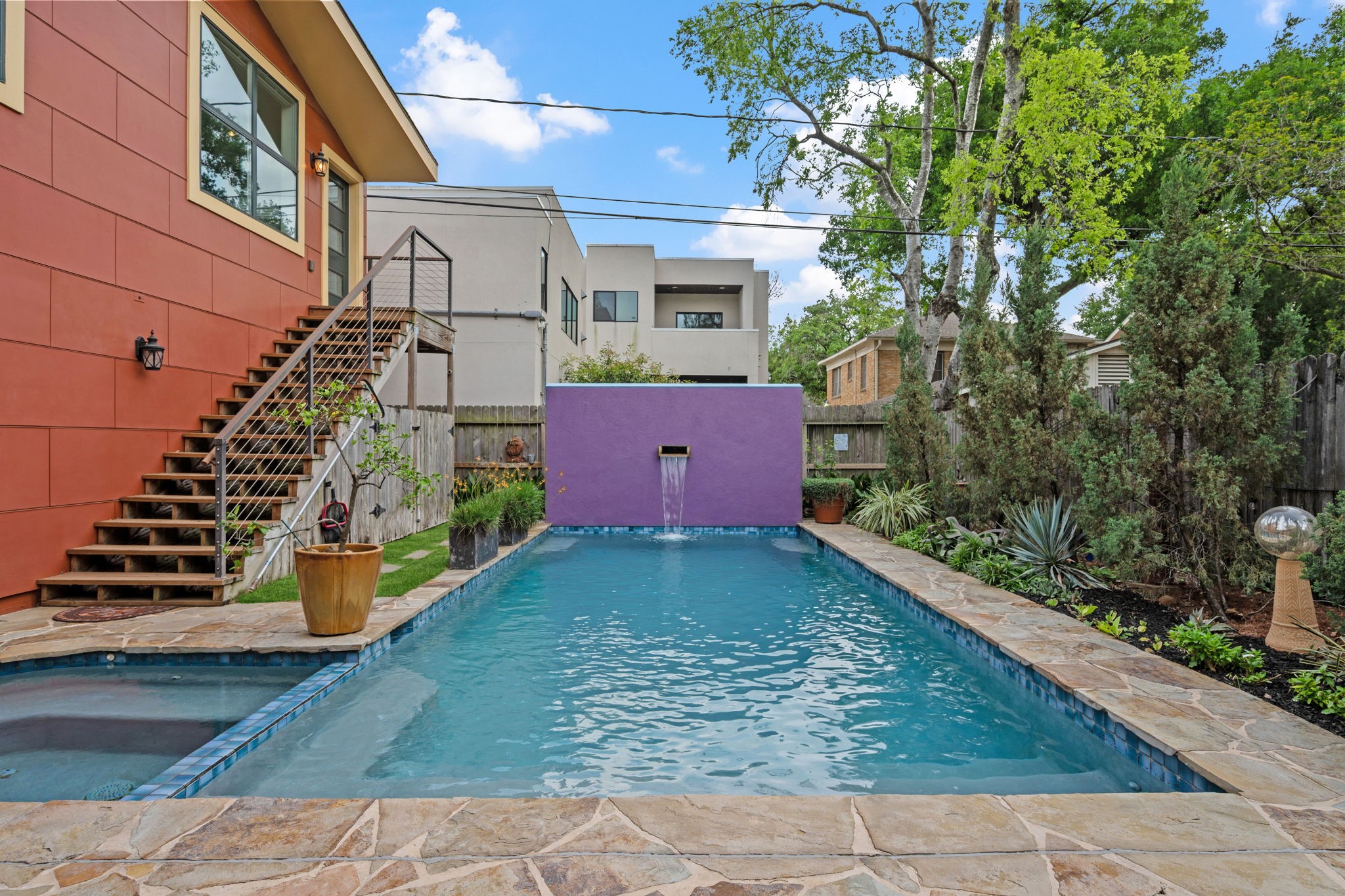 1911 Harold Street Houston, TX 77098 - Photo 28 of 36 A resort-like backyard setting offers an ideal backdrop for cooling off during Houston summers or hosting weekend get-togethers, featuring a heated pool and spa with waterfall feature (resurfaced with new heater in 2024), with views of the garage apartment located to the left of the photo.