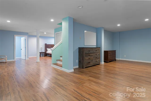 a view of kitchen with kitchen island wooden floor and living room
