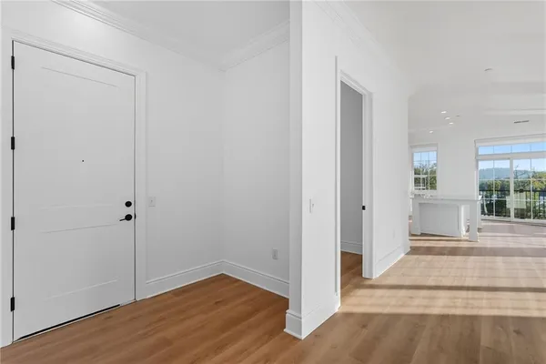 a view of a hallway with wooden floor and entryway