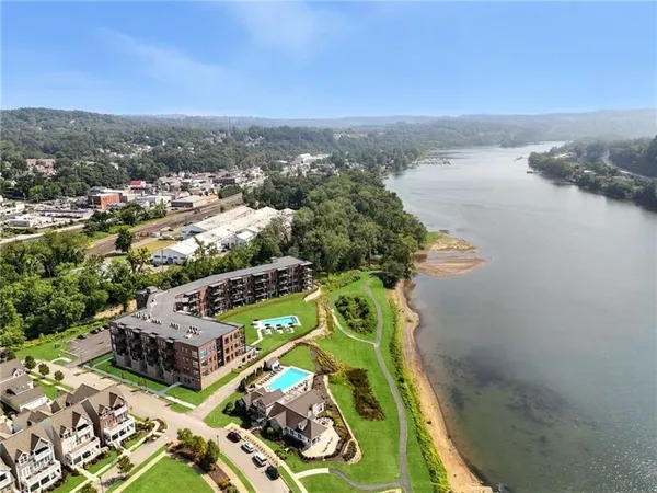 an aerial view of a swimming pool with outdoor seating and yard