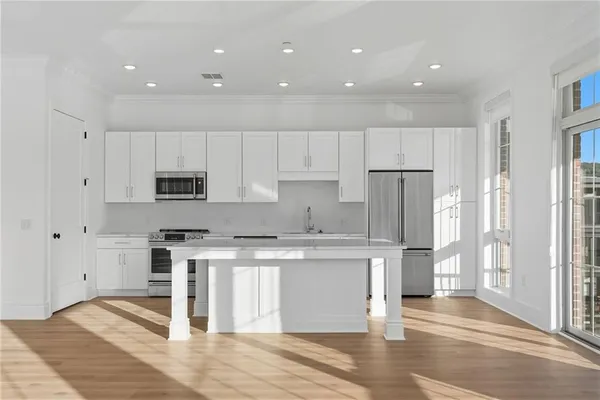 a large kitchen with stainless steel appliances granite countertop a stove a refrigerator and a sink with granite countertops