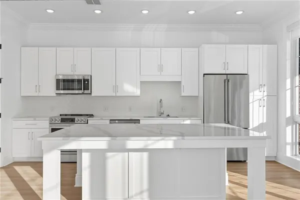 a kitchen with stainless steel appliances granite countertop a stove a sink and a refrigerator