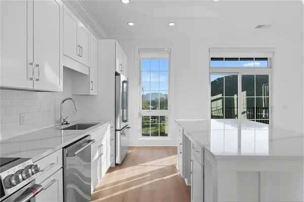 a kitchen with stainless steel appliances granite countertop a sink and a stove