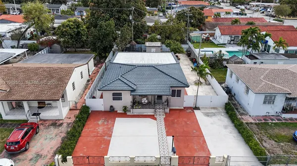 an aerial view of a house with swimming pool and furniture