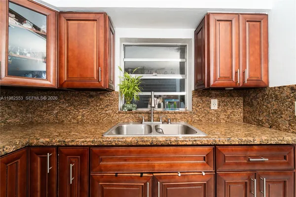 a kitchen with granite countertop stainless steel appliances a sink and a window