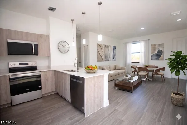 a kitchen with kitchen island granite countertop a stove and a wooden floors