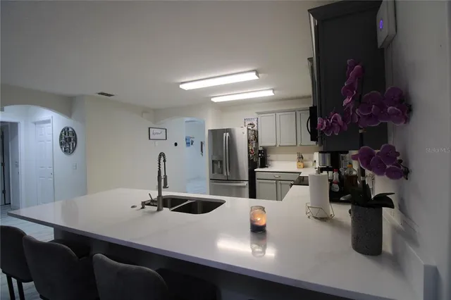 a kitchen with a sink a stove and chairs
