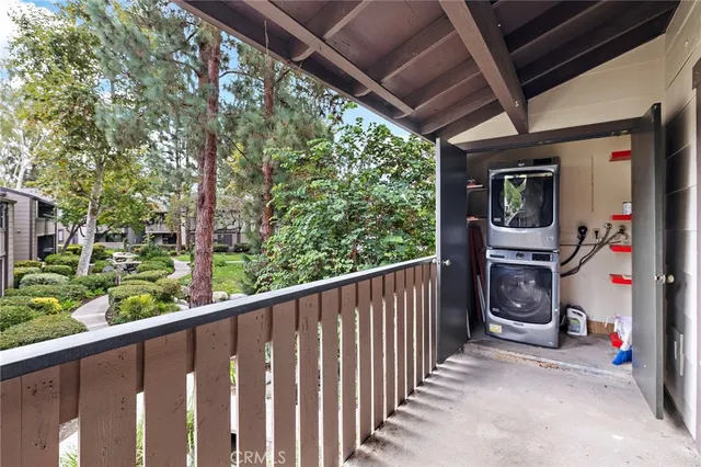 a view of a multi story residential apartment building with a yard and large trees