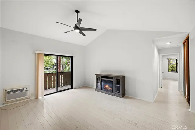 a view of empty room with fireplace and wooden floor